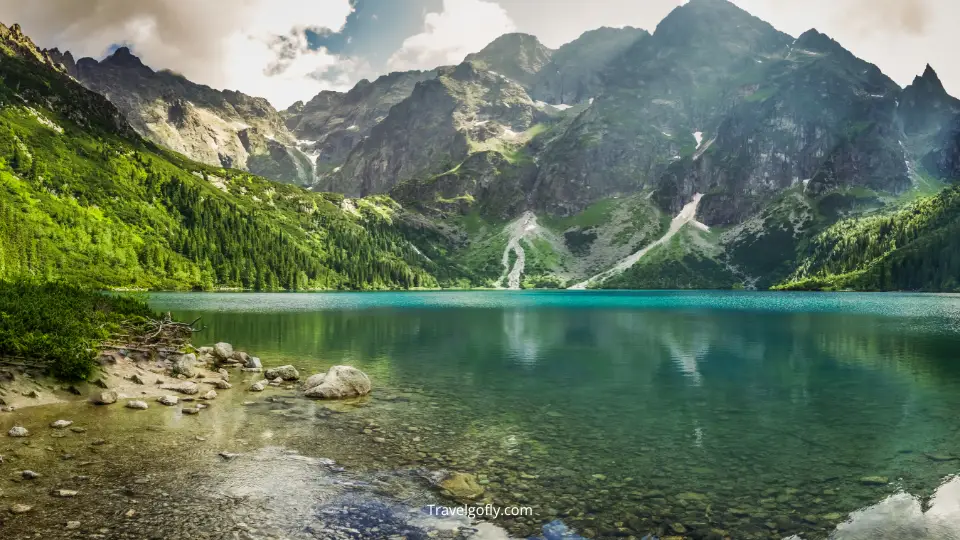 Panoramic view of Wallowa Lake with the Wallowa Mountains reflected in the crystal-clear water during golden hour