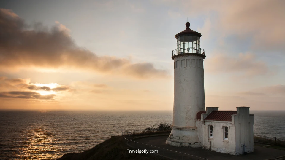 Sunset view from Cape Blanco with lighthouse silhouetted against colorful sky and ocean horizon